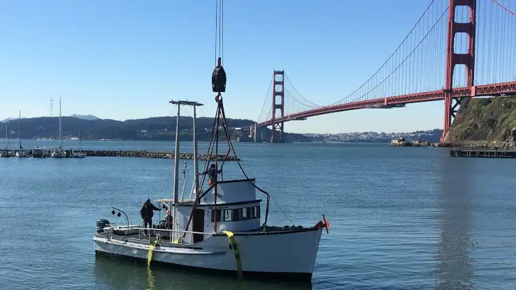 Hoisting historical salmon fishing boat from the water at the Bay Area Discovery Museum in Sausalito, CA